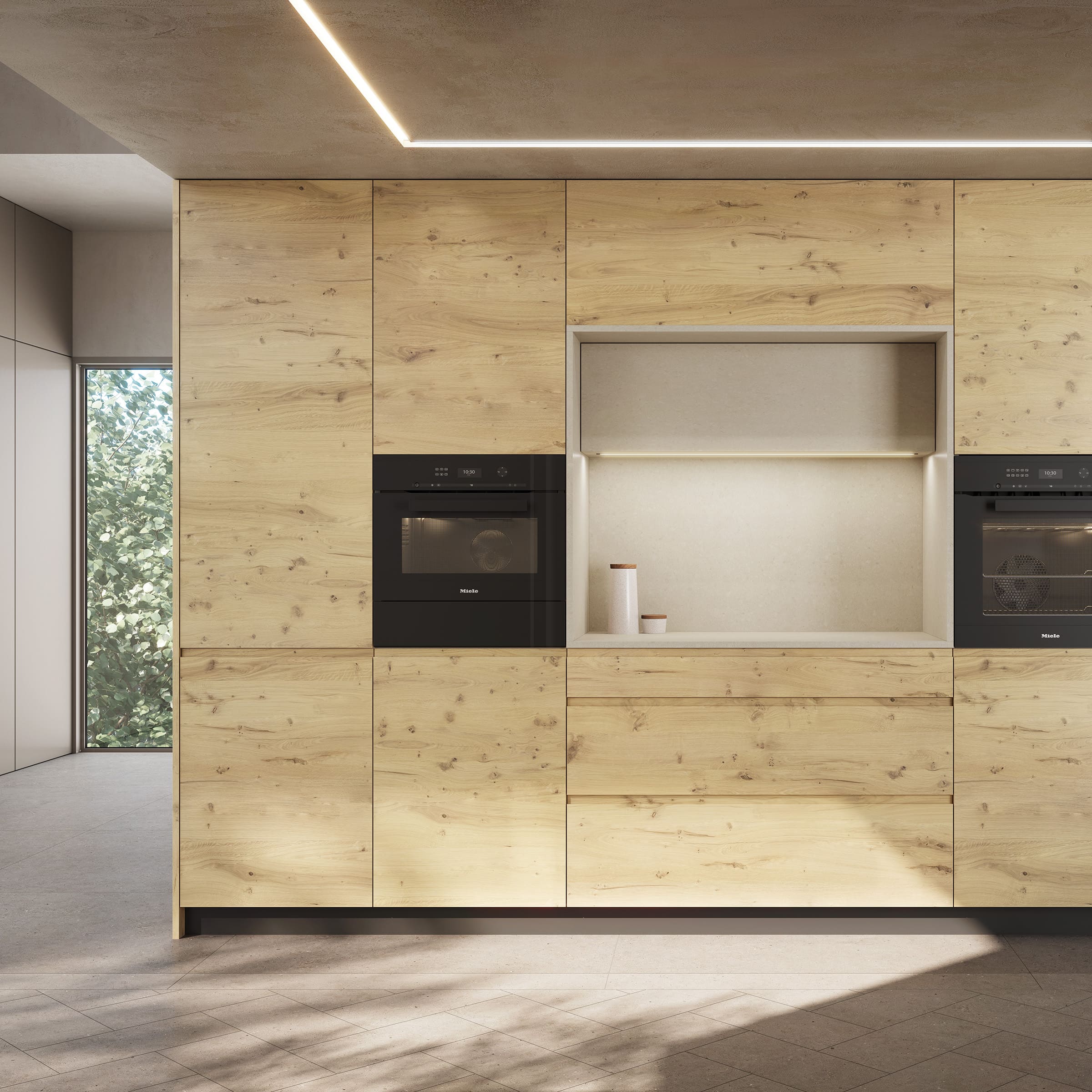 Frente de cocina con muebles altos de madera clara y hornos integrados.